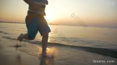 慢动作斯坦尼康拍摄的一个小孩赤脚在水沿着海岸美丽的景色与日落和